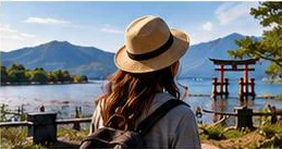 湖のほとりの鳥居を眺める旅人