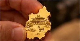 指でつまんだ奈良県の純金ピース